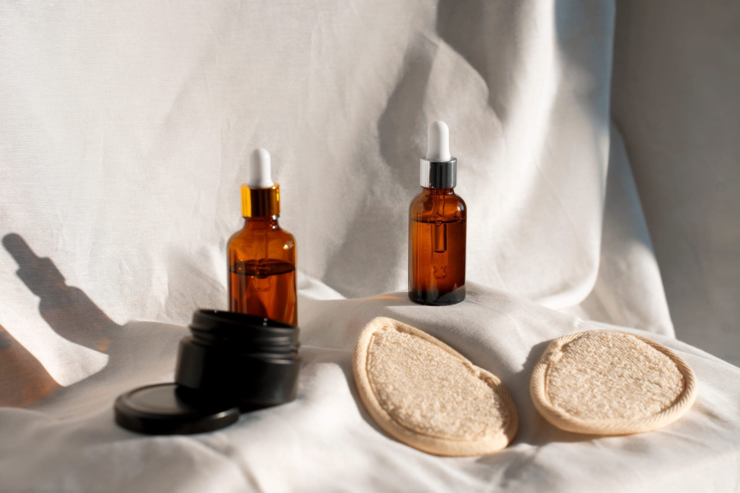 Skincare serums and natural textures on soft linen